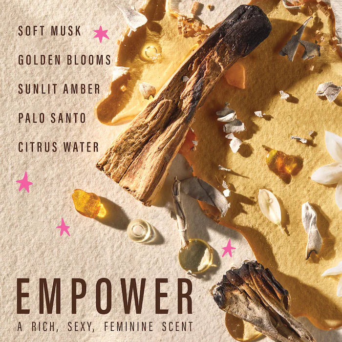 Empower shampoo fragrance graphic listing soft musk, golden blooms, sunlit amber, palo santo and citrus water beside wood, petals and amber-colored pieces.