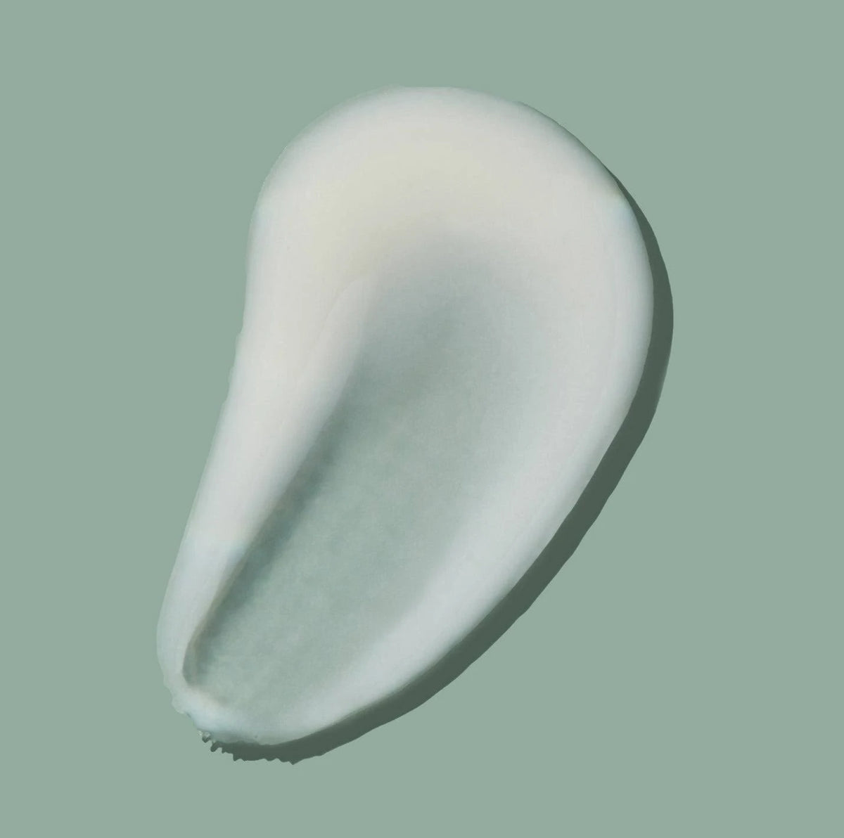 Milk Cleanse component cream texture swatch on a muted green background
